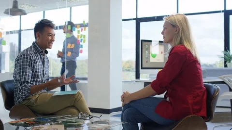 4K Young designers collaborating on a project in creative office Stock Footage 76023221