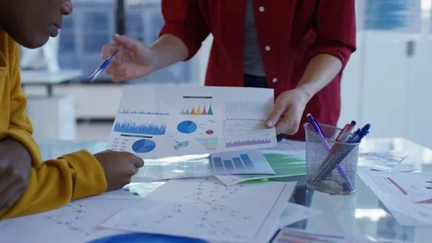 4K Young designers looking over the company figures &amp; brainstorming for ideas Stock Footage 76030359
