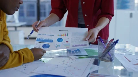 4K Young designers looking over the company figures &amp; brainstorming for ideas Stock Footage 76030635