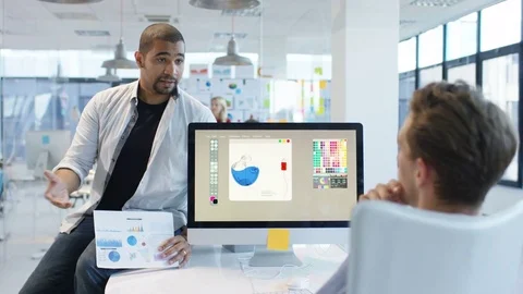 4K Young designers looking over the company figures &amp; brainstorming for ideas Stock Footage 76031036