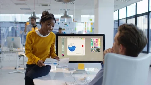 4K Young designers looking over the company figures &amp; brainstorming for ideas Stock Footage 76031279