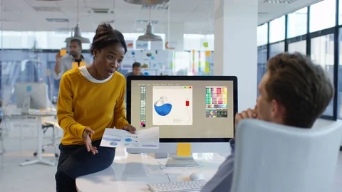4K Young designers looking over the company figures &amp; brainstorming for ideas Stock Footage 76031340