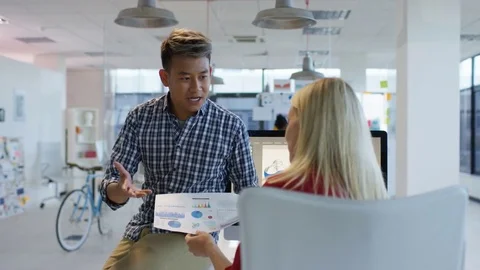 4K Young designers looking over the company figures &amp; brainstorming for ideas Stock Footage 76031503