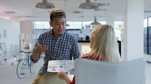 4K Young designers looking over the company figures &amp; brainstorming for ideas Stock Footage 76031519