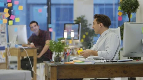 4K Young designers working on computers &amp; chatting in creative office Stock Footage 76007923