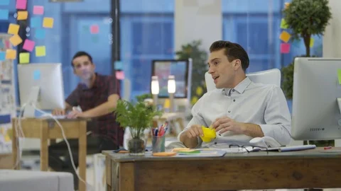 4K Young designers working on computers &amp; chatting in creative office Stock Footage 76008541