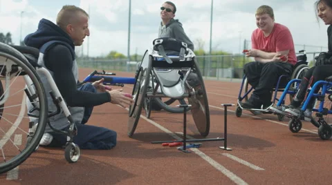 4K Young disabled adults taking advice from experienced athlete in sports sessio Stock Footage 64576575