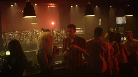 4K Young diverse group socializing &amp; bar staff serving drinks in trendy city bar Stock Footage 64958130