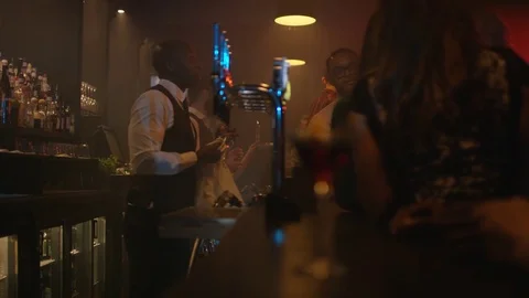 4K Young Diverse Group Socializing &amp; Bar Staff Serving Drinks In Trendy City Bar Stock Footage 75797983