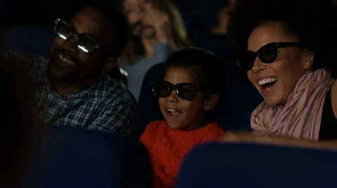 4K Young family watching a film with 3D glasses in crowded movie theatre Stock Footage