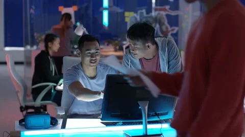 4K Young game designers looking at computer screen &amp; discussing ideas Stock Footage 67556406