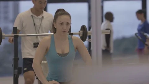 4K Young group working out in the gym, trainer spotting for girl lifting weights Video stock 75861771