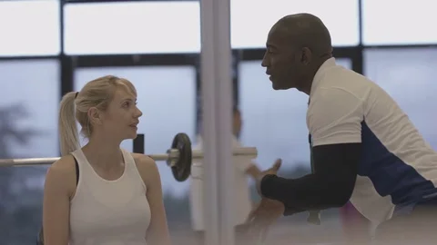 4K Young group working out in the gym, trainer spotting for girl lifting weights Video stock 75862146