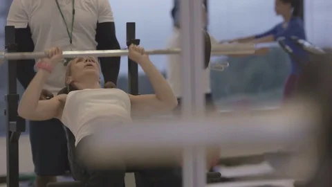 4K Young group working out in the gym, trainer spotting for girl lifting weights Video stock 75862202