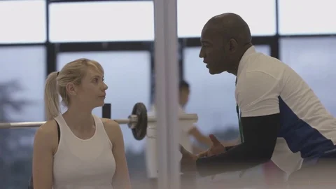 4K Young group working out in the gym, trainer spotting for girl lifting weights Video stock 75862479