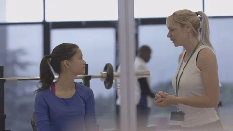 4K Young group working out in the gym, trainer spotting for girl lifting weights Video stock 75862564