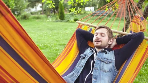 4k Young Happy Man Relaxing In Hammock At Garden Stock Footage