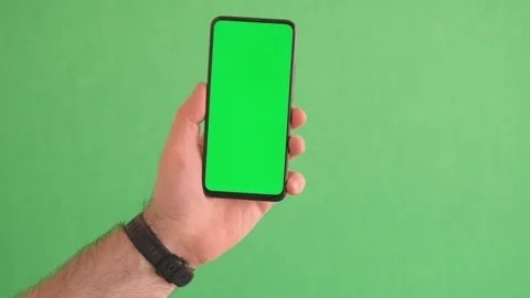 4K Young man hand touch smartphone with green screen on green background Stock Footage 243274081