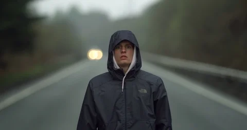 4K Young Man in Headlights walking on Road in the Scottish Glen Coe Mountains. Stock Footage 93083378