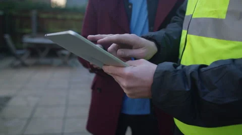 4K Young man outside his home getting planning advice from builder or architect Stock Footage 49640704