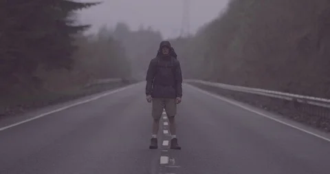 4K Young Man in Road in the Scottish Glen Coe Mountain Highlands. Traveller. Stock Footage 93084394