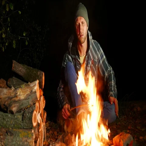 4k . young man roasting marshmallows at camp fire Stock-Footage 69699706