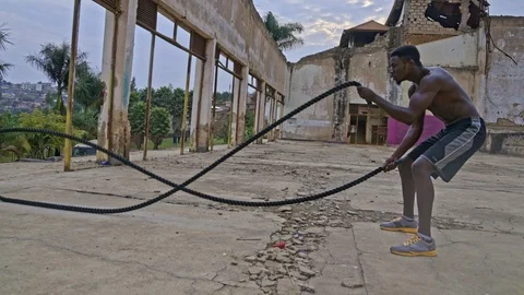 4k Young man training with battle rope Видео 115769993