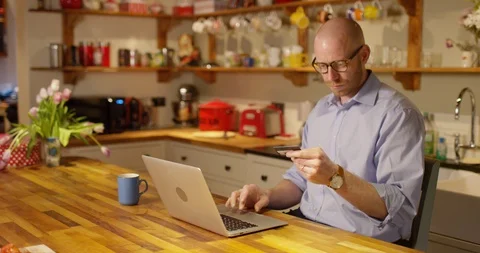 4k Young man using a credit card for online shopping at home Stock Footage 128390997