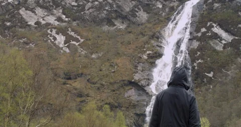 4K Young Man viewing A Waterfall at the Glen Coe Scottish Mountains in Scotland. Stock Footage 93088677