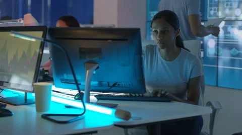 4K Young mixed ethnicity computer game design team working in dark office Video stock 67899261