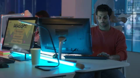 4K Young mixed ethnicity computer game design team working in dark office Video stock 67899371