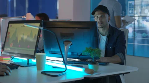 4K Young mixed ethnicity computer game design team working in dark office Video stock 67899418