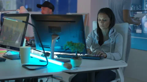 4K Young mixed ethnicity computer game design team working in dark office Video stock 67899437