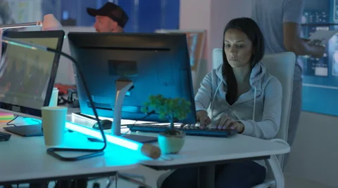 4K Young mixed ethnicity computer game design team working in dark office Video stock 67899467