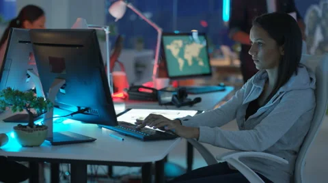 4K Young mixed ethnicity computer game design team working in dark office Video stock 67899505