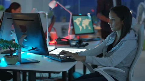 4K Young mixed ethnicity computer game design team working in dark office Video stock 67899556