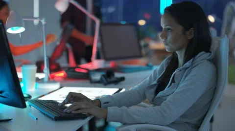 4K Young mixed ethnicity computer game design team working in dark office Video stock 67899662