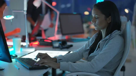 4K Young mixed ethnicity computer game design team working in dark office Video stock 67899847