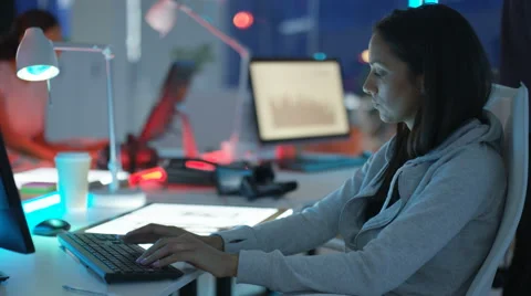 4K Young mixed ethnicity computer game design team working in dark office Video stock 67899955
