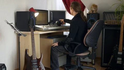 4K Young Musician Composing, Playing and Recording Music on Computer Workstation Stock Footage 107005778