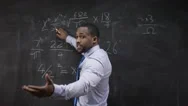 4K Young Teacher Writing Math Formula On Blackboard &Amp; Addressing Students Stock Footage