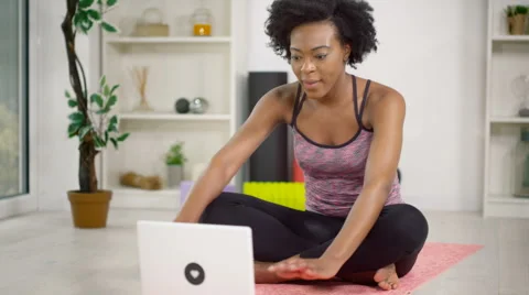 4K Young woman using a laptop computer to follow a workout at home Video stock 61143853