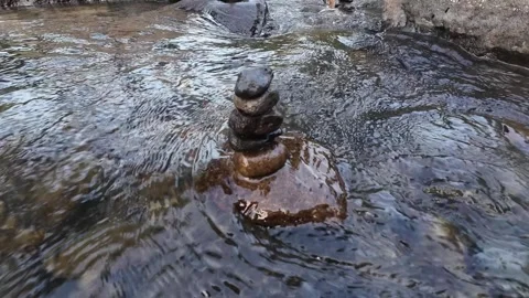 4K Zen Stone Stack in Flowing River Water with Natural Forest Background Stock Footage 336749938