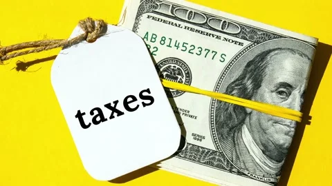 4k zoom in out Paper note written word TAXES in black letters around Us Dollars Stock Footage 222925973