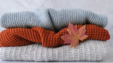 4k zoom in out Stack of cozy knitted warm sweater with Autumn fall maple leaf Stock Footage 217434106