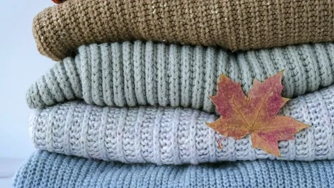 4k zoom in out Stack of cozy knitted warm sweater with Autumn fall maple leaf Stock Footage 220334311