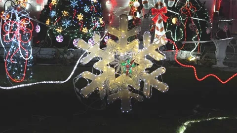 4K60fps Large lighted snowflake holiday decoration adorns this homes front yard Video stock 166649815