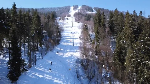   4k.Aerial. Winter time in mountain ski resort. Up over  skiing lift  Stockbeeldmateriaal 87203608