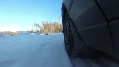 4K.Car goes on winter forest or  park. View of  wheel, POV clip Stockbeeldmateriaal 85396273