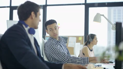 4KCheerful customer support team with headphones working at computers &amp; chatting Stock Footage 64517951